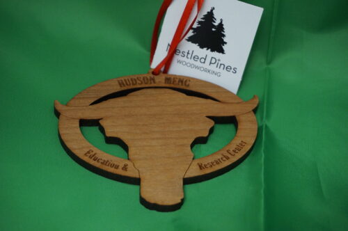 Hudson Meng ornament. Wooden oval with a stylized bison head and the words "Hudson-Meng Education and Research Center"