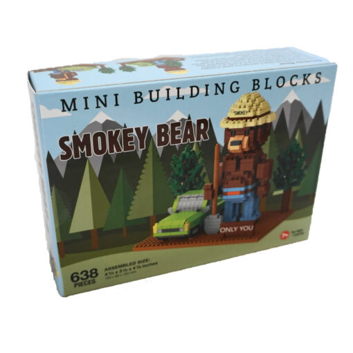 The box for the Smokey Bear mini building blocks set. The front of the box shows an image of the assembled model, including Smokey Bear, a green car, trees, and a base with a sign reading 'Only You.' The box design features a forest and mountain background, with the text 'Mini Building Blocks Smokey Bear' prominently displayed. It indicates 638 pieces and an assembled size of 4 ¾ inches tall, 3 ⅛ inches wide, and 4 ⅞ inches deep. The set is labeled for ages 7 and up.