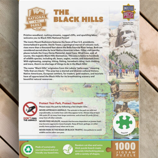 The back of a jigsaw puzzle box featuring the Black Hills National Forest. Text describes the natural beauty, wildlife, and cultural history of the region, including attractions like Mount Rushmore, Jewel Cave, and Crazy Horse Memorial. It includes a 'Protect Your Park' section with guidelines on responsible behavior in nature, along with eco-friendly puzzle manufacturing details.