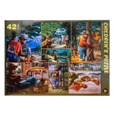 The front of the Smokey Bear Children's Puzzle box, showcasing colorful artwork in a grid format. Each panel features Smokey Bear in scenes like digging a tree hole, interacting with forest visitors, and relaxing in nature. The text highlights that the puzzle contains 42 pieces and is suitable for ages 3 and up.