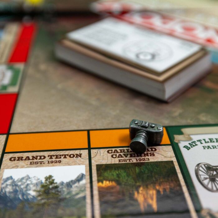 Detail shot of National Park Monopoly board with cards and camera player token.