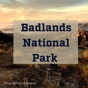 Badland geologic features at sunset with the text: Badlands National Park 