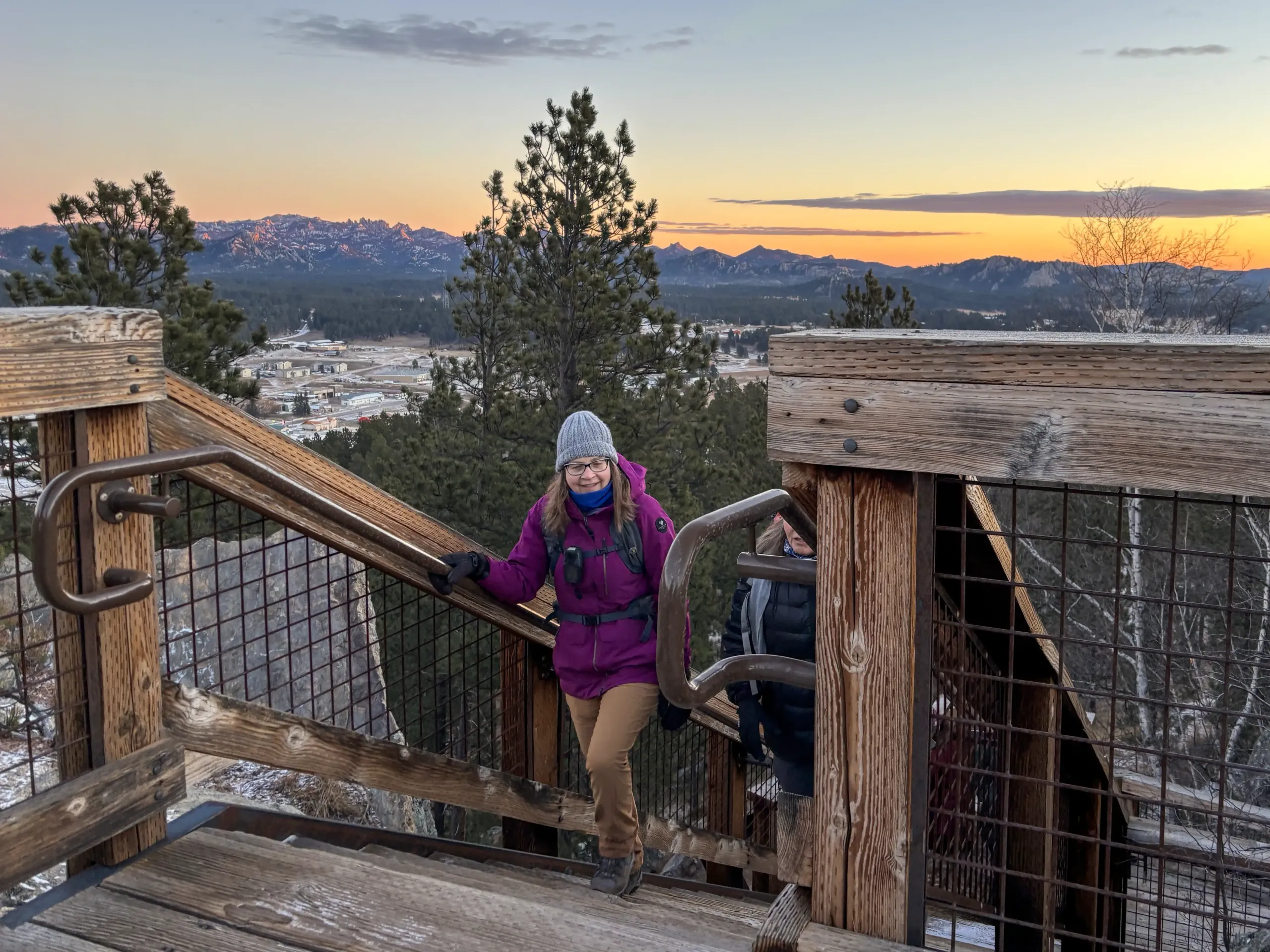 Group of women at a fire tower overlook watching the sunrise over Black Elk Peak during BHPFA's Winter Solstice hike