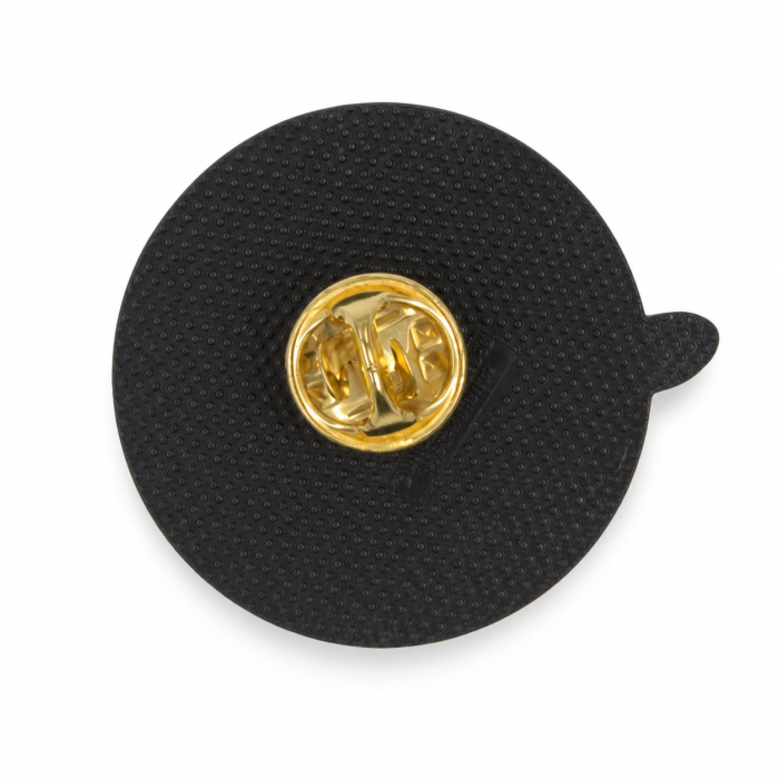 Reverse of the round pin, showing a gold butterfly-clutch fastener at the center of a black backing pad.