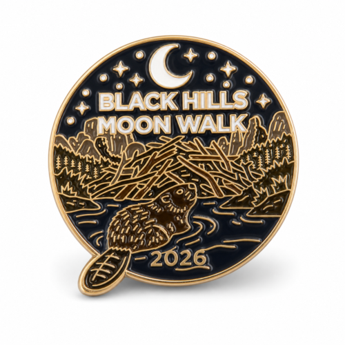 Round enamel lapel pin with a navy blue background and gold artwork. A beaver swims across water beneath a crescent moon and stars, with a Black Hills ridgeline and pine trees behind it. The pin reads Black Hills Moon Walk above the scene and is dated 2026 at the bottom.
