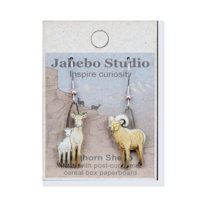 Jabebo Studio dangle earrings shaped like bighorn sheep, a ewe and a curl-horned ram, made of layered recycled paperboard, shown on the product card.