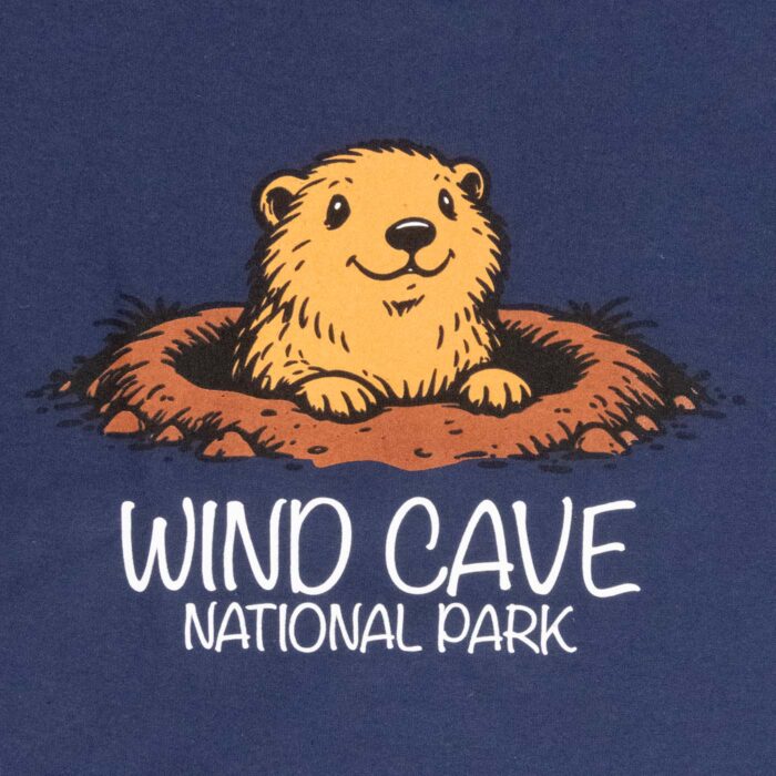 Close-up of the Wind Cave National Park t-shirt graphic, a smiling cartoon prairie dog rising from its burrow, lettered Wind Cave National Park.