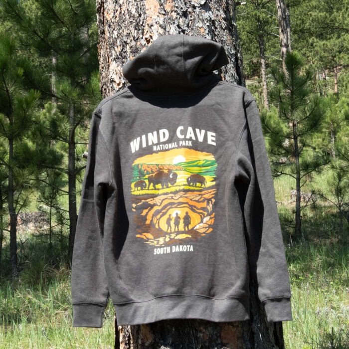 Wind Cave hoodie displayed on a ponderosa pine in the Black Hills, the back graphic facing out.