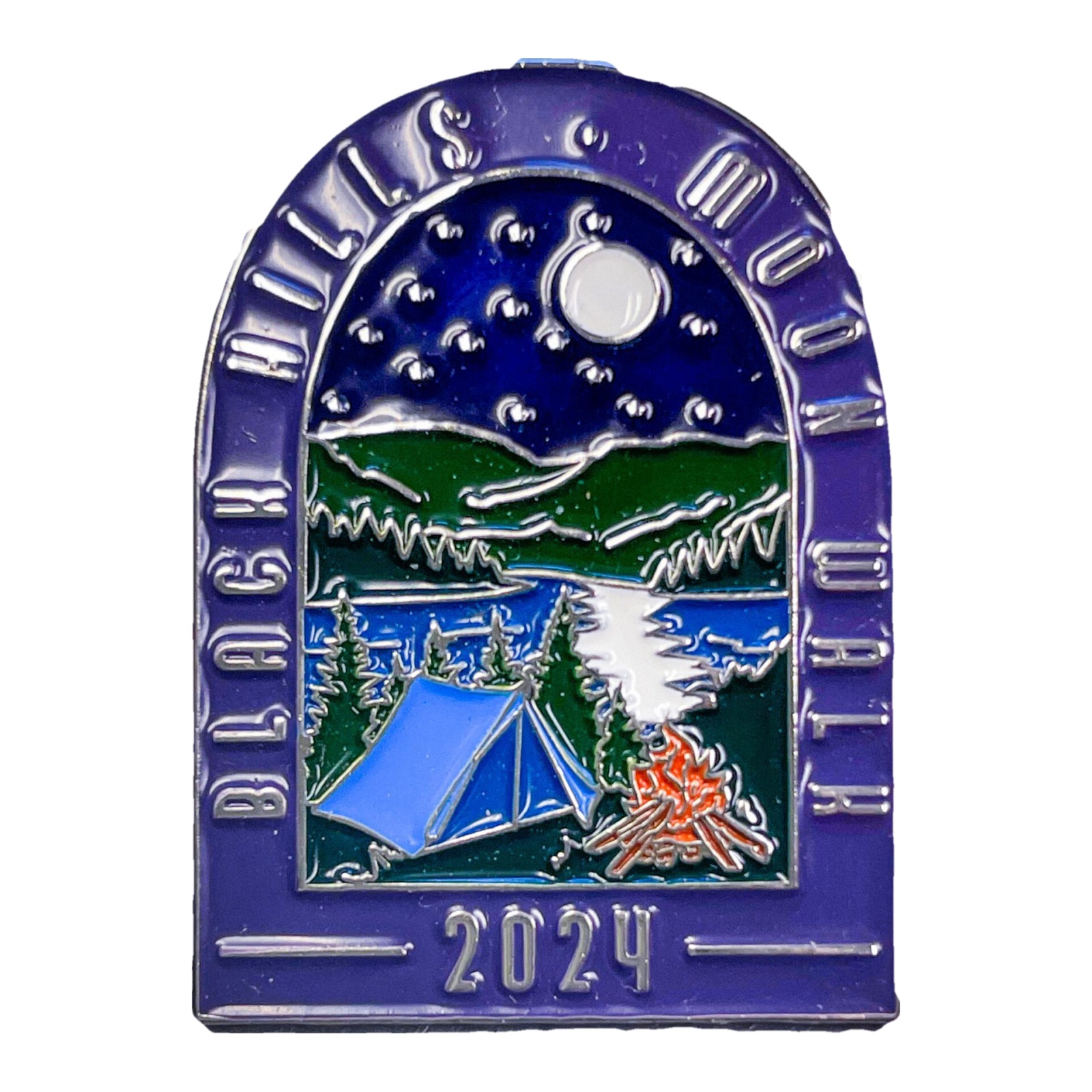 Arched enamel lapel pin with a purple border reading Black Hills Moon Walk in raised silver letters. Inside the arch, a night scene shows a full moon and stars above green hills, a lake, pine trees, a blue tent, and an orange campfire. The pin is dated 2024 at the bottom.