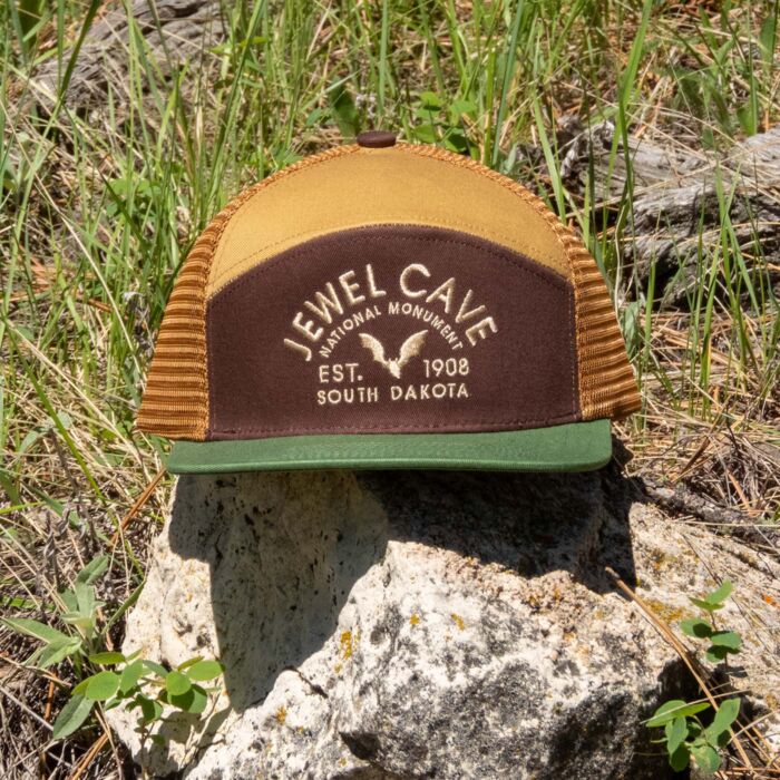 Jewel Cave National Monument camper hat resting on a limestone rock in grass and pine needles
