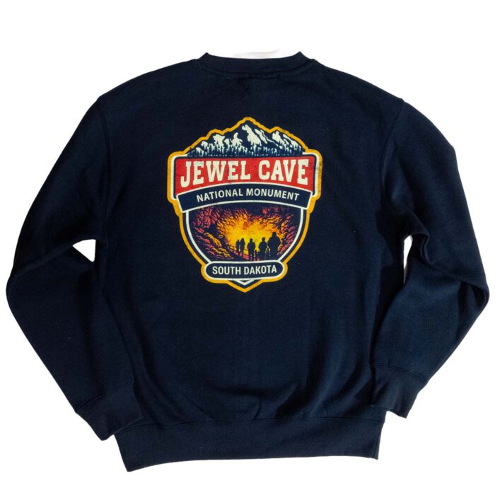 Back of the navy Jewel Cave National Monument sweatshirt, large faded badge with a cave-tour scene
