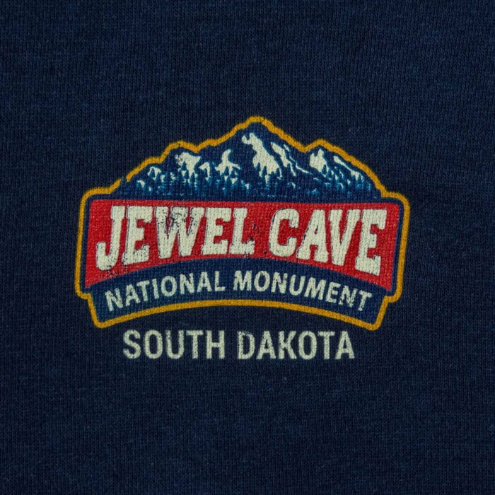 Close-up of the Jewel Cave National Monument left-chest badge, snow-capped mountains over South Dakota