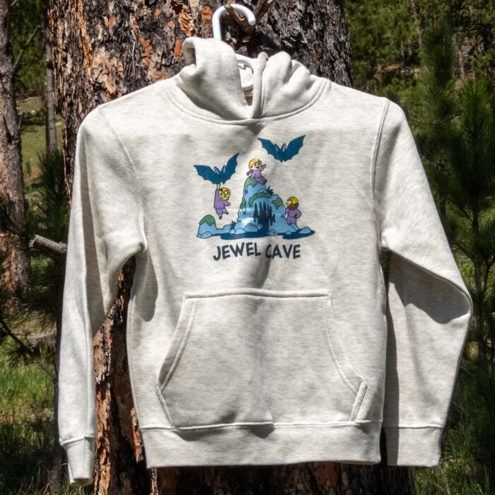 Oatmeal Jewel Cave youth bats hoodie on a hanger outdoors, front view