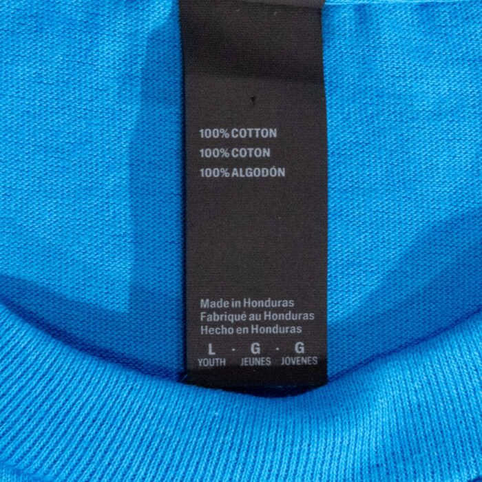 Neck label on the youth t-shirt reading 100% cotton, made in Honduras, youth size large