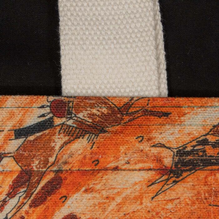 Stitching where the natural cotton handle meets the printed art panel of the Maka Oniye tote bag