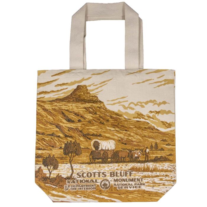 Scotts Bluff canvas tote bag, back, with a single covered wagon and team at the base of the bluff