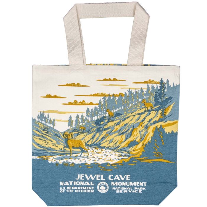 Reverse of the tote: bighorn sheep in a wooded draw above a dry gravel wash, pines along the ridge, in WPA poster style.